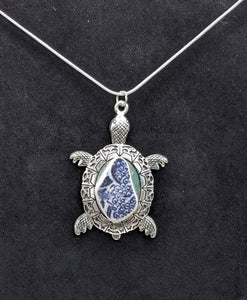 Silver sea turtle with blue and white pottery